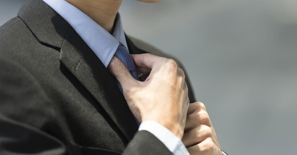 Un jeune diplômé prépare sa cravate pour son premier entretien